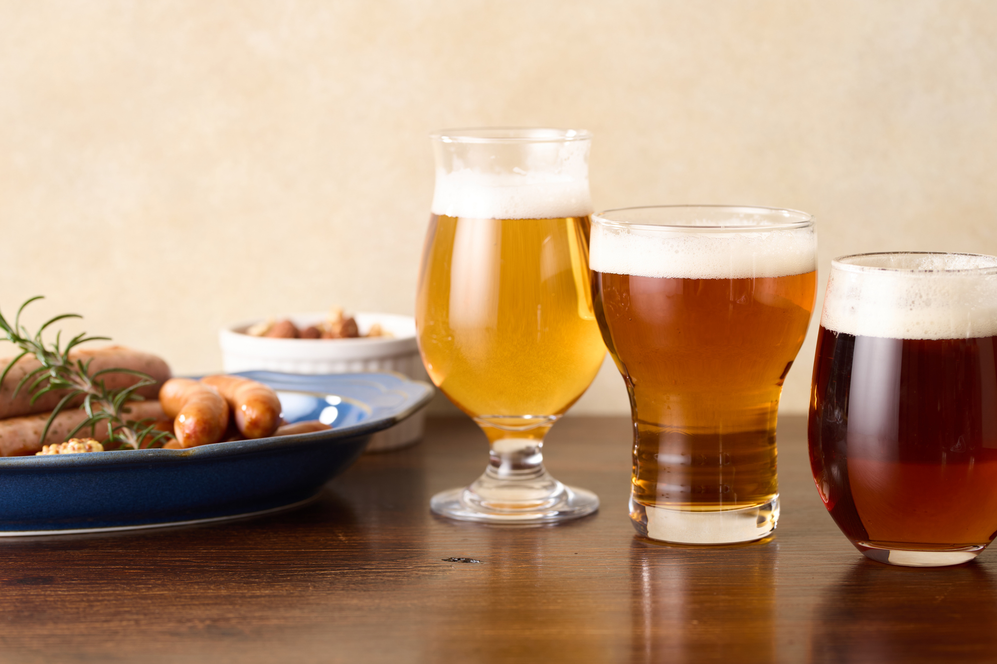 木のテーブルに並ぶクラフトビールのグラスと料理